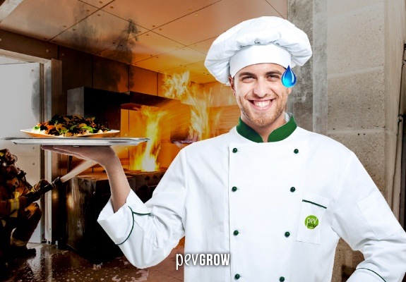 Immagine di un cuoco che sorride nonostante tutti gli incidenti nella sua cucina.